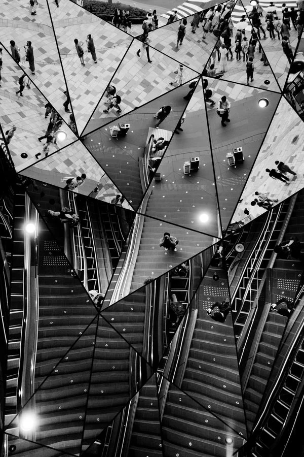 A fragmented mirrored interior with repeating architectural reflections